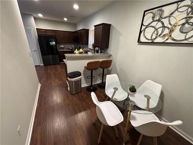 Kitchen with freestanding refrigerator, light countertops, dark wood finished floors, dark brown cabinets, and recessed lighting