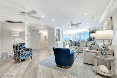Living room featuring crown molding, ceiling fan, baseboards, and light wood-style flooring