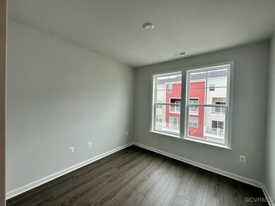 Unfurnished room featuring baseboards, dark wood finished floors, and visible vents