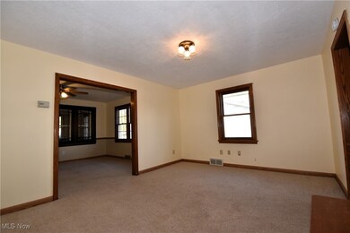 Spare room featuring light carpet, ceiling fan, and a textured ceiling