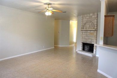 Unfurnished living room with ceiling fan, a firep