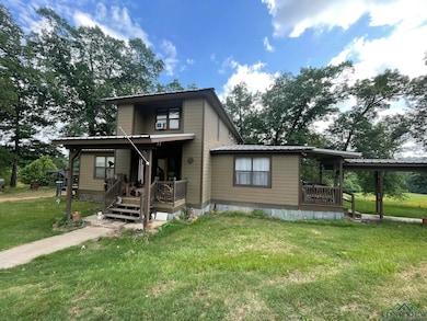 Modern home featuring a front yard, covered porch, and metal roof