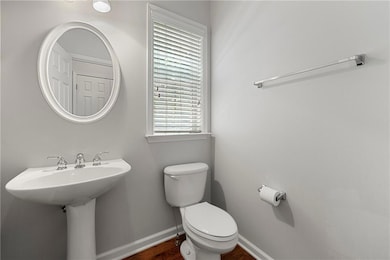 Half-Bathroom featuring toilet and wood finished floors
