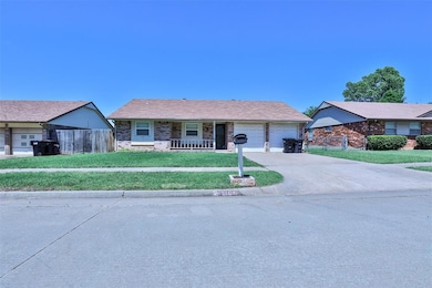 Ranch-style home featuring an attached garage, covered porch, and driveway