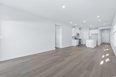 Unfurnished living room featuring light hardwood /