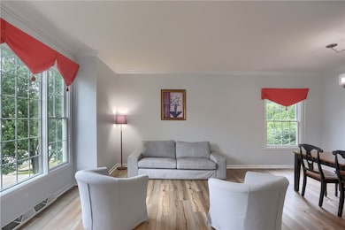 Huge windows flood the living room with natural light and glistens on the sprawling modern flooring.