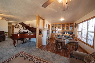 Office area featuring a textured ceiling, dark wood-type flooring, and a ceiling fan