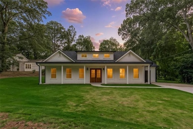 Modern farmhouse with french doors, board and batten siding, a porch, a front yard, and concrete driveway