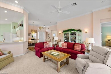 Carpeted living room with crown molding, a chandelier, a ceiling fan, and recessed lighting