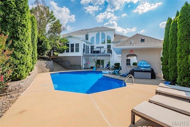 Outdoor pool with stairs and a patio area