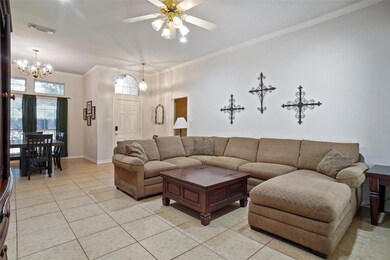 Living room featuring crown molding, light tile pa
