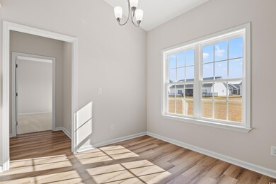 Spare room with a chandelier and light hardwood / wood-style flooring