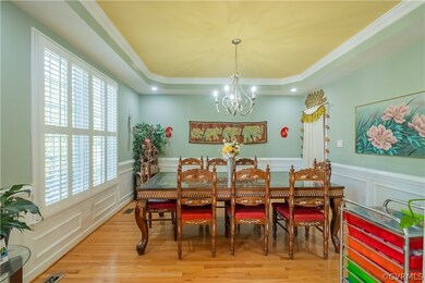Dining area with wood-type flooring, plenty of natural light, and a raised ceiling