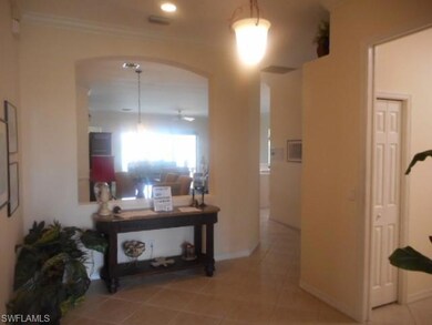 Hall featuring arched walkways, tile patterned floors, and crown molding