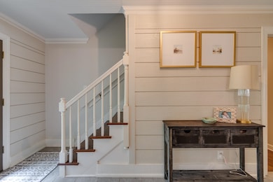 Staircase featuring crown molding and baseboards