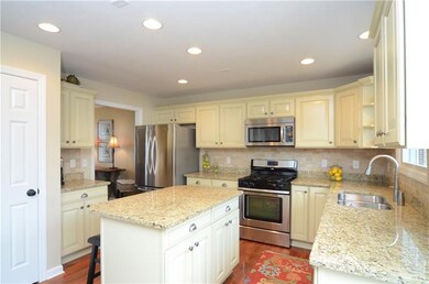 The kitchen also includes hardwood floors, stainle