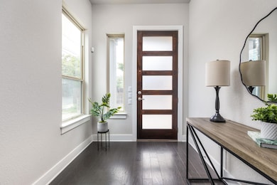 Entrance foyer featuring baseboards and dark wood