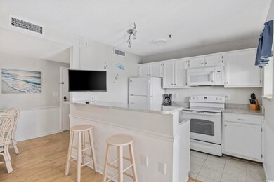 Kitchen featuring white cabinetry, white appliances, and visible vents