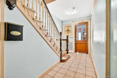 Entryway with stairs and light tile patterned flooring
