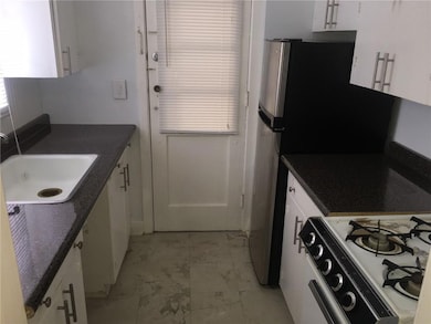 Kitchen with light marble finish floors, a sink, a