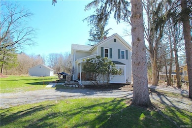 House with detached garage in background. The driv