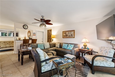 Living area with ceiling fan and light tile patter