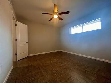 Empty room featuring a ceiling fan and baseboards