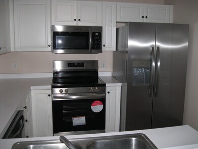 Kitchen with white cabinetry, light countertops, a