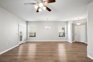 Unfurnished living room with dark wood-style floo