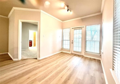 Unfurnished room with wood finished floors and ornamental molding