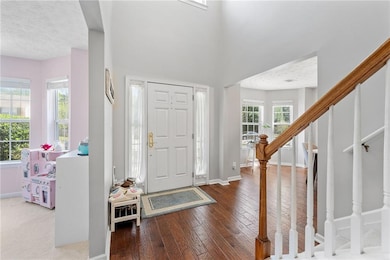 Foyer entrance featuring stairway, baseboards, har