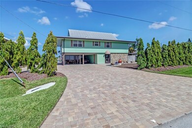 large paver entrance with mast trees