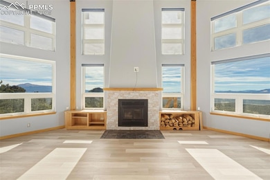Unfurnished living room featuring wood finished floors, a high ceiling, and a tile fireplace