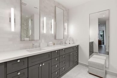 Full bath with double vanity, a stall shower, backsplash, light tile patterned floors, and recessed lighting