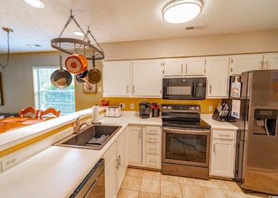 Kitchen with light countertops, visible vents, a s