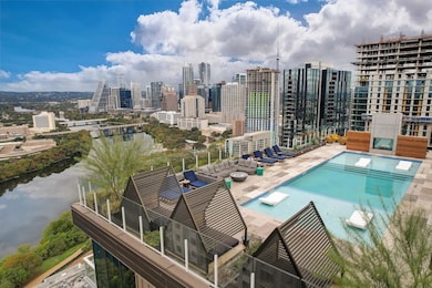 Pool with a view of city, a water view, and a pat