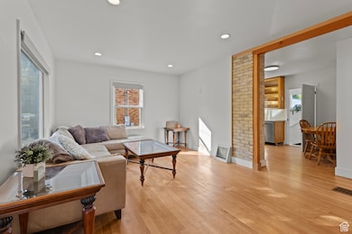 Living area featuring light wood-type flooring, plenty of natural light, and recessed lighting