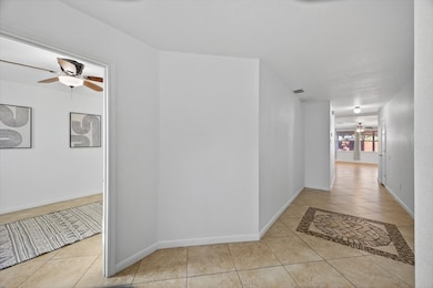 Hallway with light tile patterned floors and baseboards