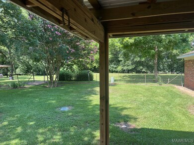View of the fenced back yard and green space.