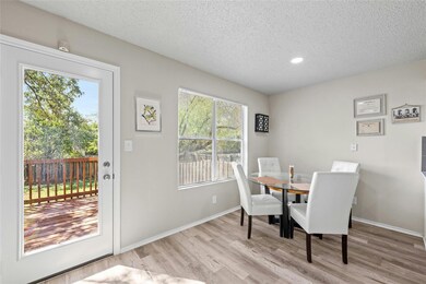 Dining room featuring baseboards, a textured ceiling, and wood finished floors