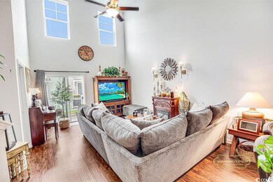 Living room with a high ceiling, a ceiling fan, an