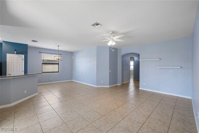 Unfurnished living room with arched walkways, a ce