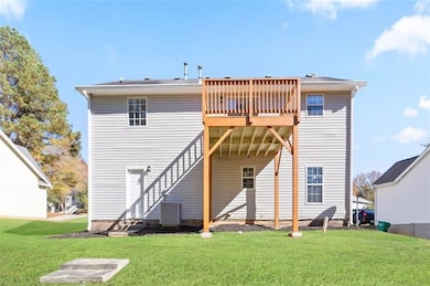 Back of property with a yard, a deck, and a patio
