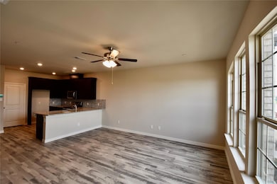Kitchen with wood-type flooring, backsplash, and ceiling fan