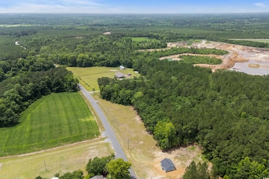 Aerial overview of property's location with a heavily wooded area and rural landscape