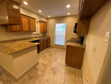 Kitchen with light stone counters, range, sink, di