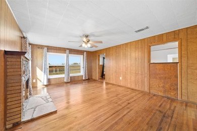Living room with panelling, ceiling fan, a firepla