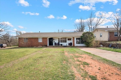 Ranch-style house featuring brick siding, covered 