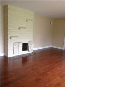 Formal living room with fireplace and wood floors.