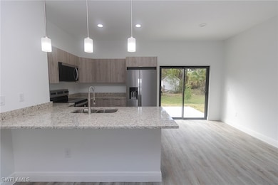 Kitchen with brown cabinetry, modern cabinets, app